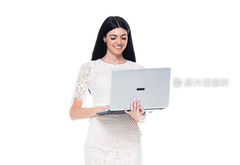 向下看/正面看/一个人/腰部以上的20-29岁的成年美丽的高加索年轻女性/女性站着穿着裙子谁是微笑/快乐/愉快/凉爽的态度谁是工作和使用笔记本电脑/电脑